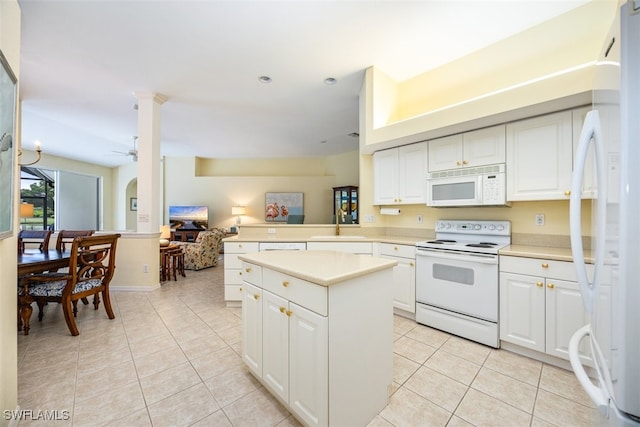 kitchen with white cabinetry, kitchen peninsula, ceiling fan, and white appliances