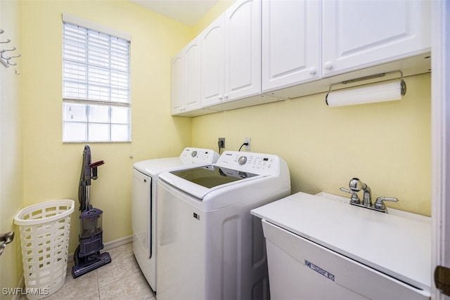 laundry room featuring cabinets, light tile patterned floors, separate washer and dryer, and sink