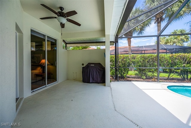 view of patio / terrace featuring area for grilling, ceiling fan, and glass enclosure