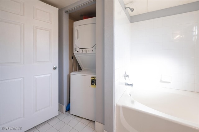 clothes washing area featuring light tile patterned flooring and stacked washer / drying machine