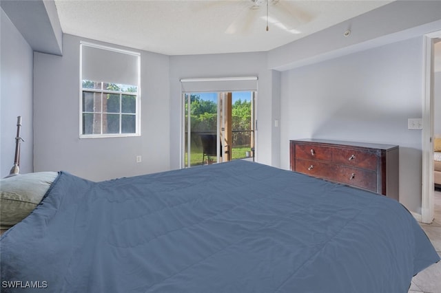 bedroom with a textured ceiling, access to exterior, and ceiling fan