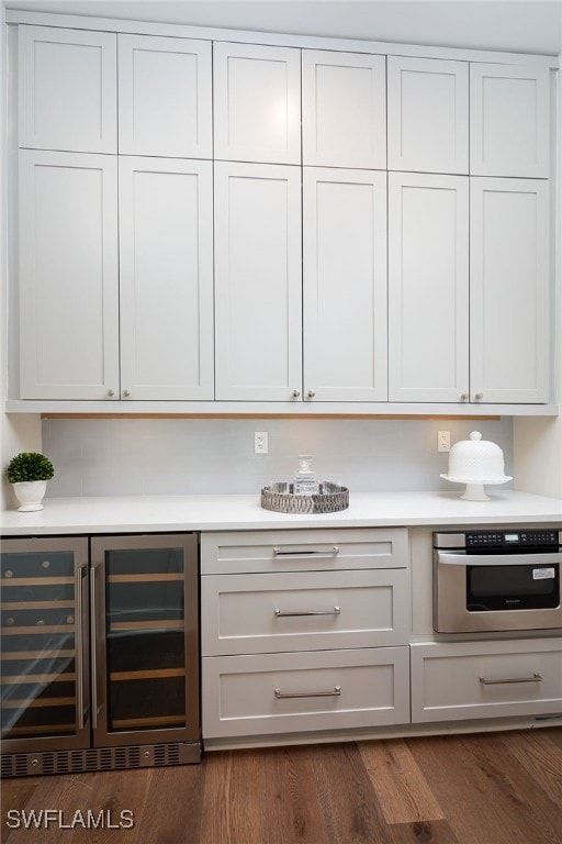 kitchen featuring wine cooler, dark hardwood / wood-style floors, stainless steel oven, and white cabinetry