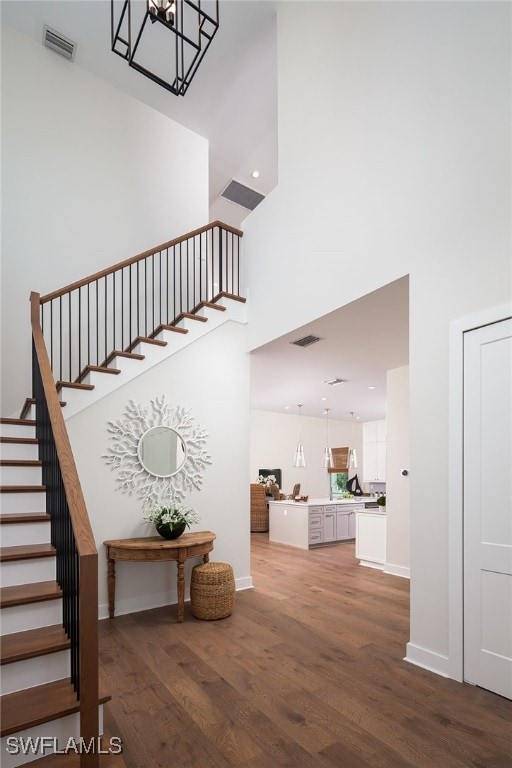 stairway featuring hardwood / wood-style floors and a towering ceiling