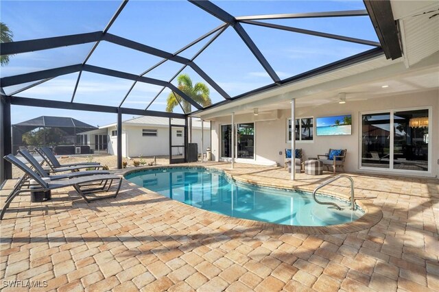 view of pool with glass enclosure and a patio area