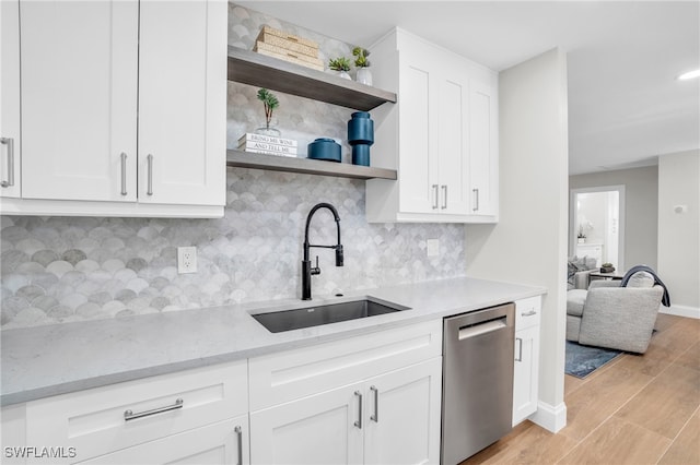 kitchen with dishwasher, sink, tasteful backsplash, light hardwood / wood-style floors, and white cabinetry