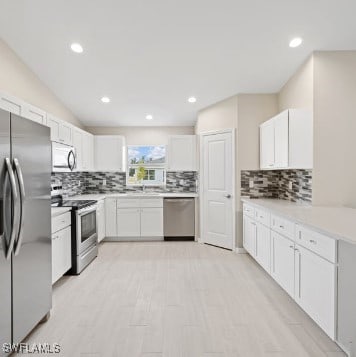 kitchen with white cabinets, appliances with stainless steel finishes, and backsplash