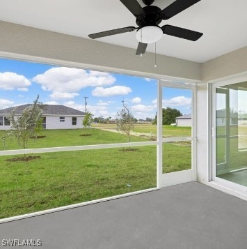 unfurnished sunroom featuring ceiling fan