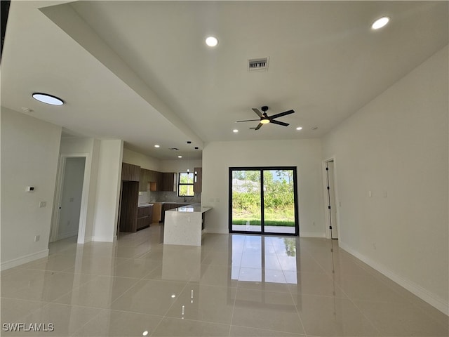 unfurnished living room featuring ceiling fan and light tile patterned floors