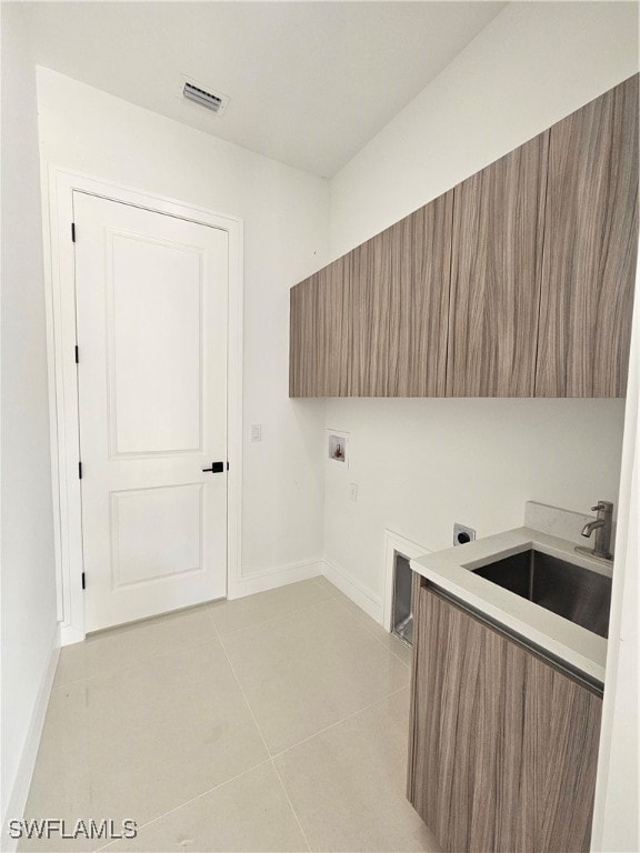 laundry area with sink, light tile patterned floors, washer hookup, and hookup for an electric dryer