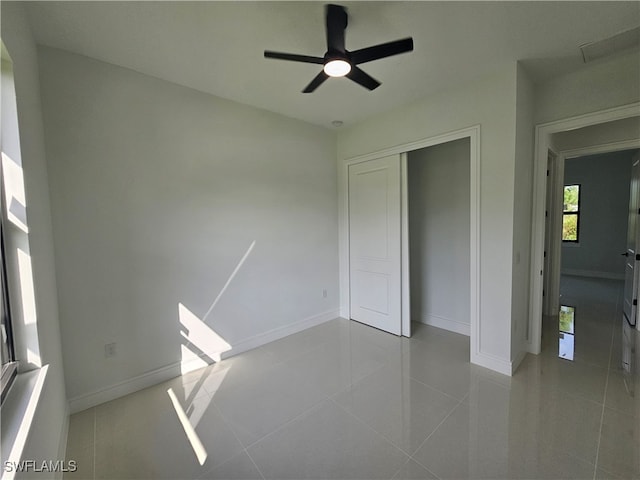 unfurnished bedroom with ceiling fan, light tile patterned floors, and a closet