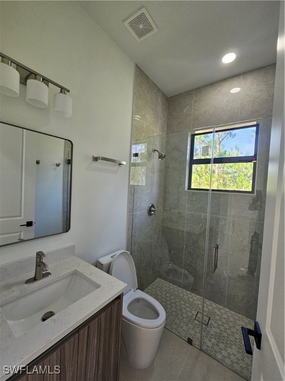 bathroom with tile patterned floors, vanity, toilet, and walk in shower