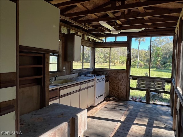 sunroom / solarium with ceiling fan, sink, and vaulted ceiling