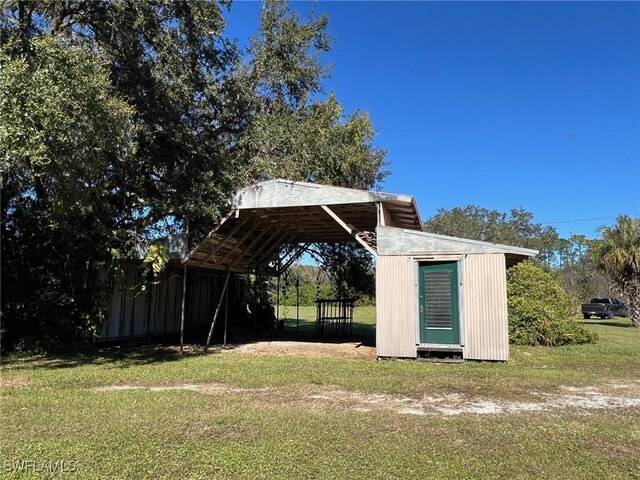 1603 Tom Coker Rd, Labelle, FL 33935 - view of green lawn with a detached carport and a storage unit