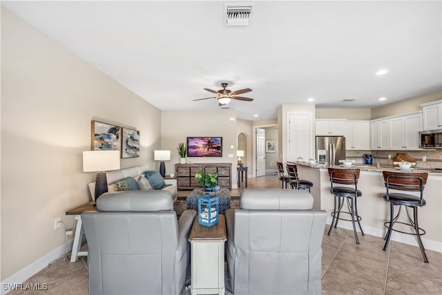 tiled living room featuring ceiling fan