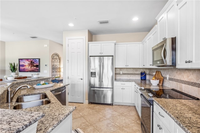 kitchen with stainless steel appliances, white cabinets, sink, and decorative backsplash