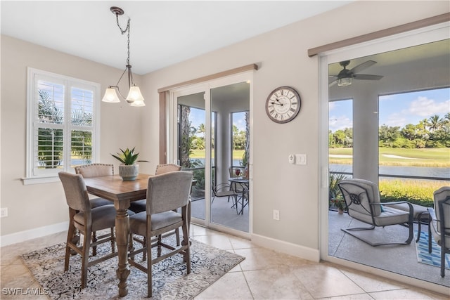 dining space with light tile patterned floors and ceiling fan with notable chandelier