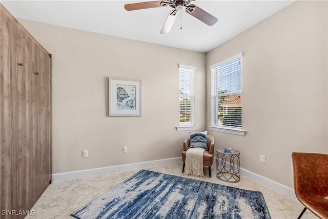 sitting room featuring light tile patterned floors and ceiling fan