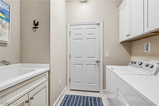 washroom with sink, cabinets, washing machine and clothes dryer, and light tile patterned flooring