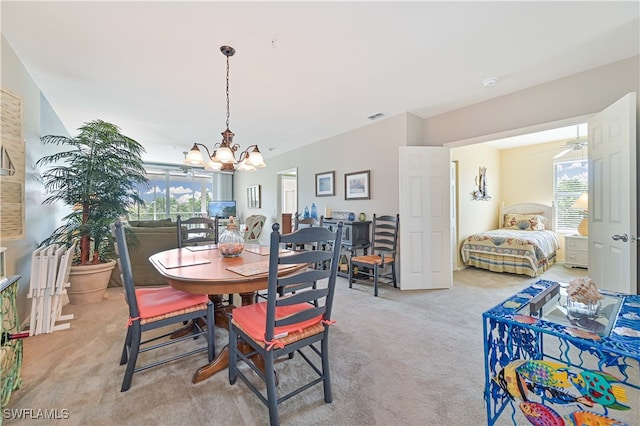 carpeted dining space with a notable chandelier and a healthy amount of sunlight