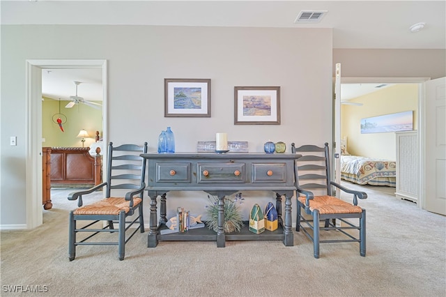 interior space with ceiling fan and light colored carpet