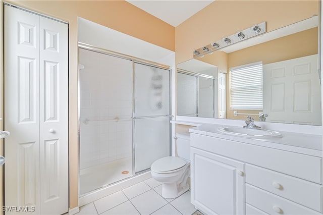 bathroom featuring vanity, toilet, tile patterned floors, and walk in shower