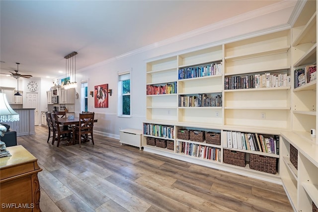 interior space featuring crown molding, wood-type flooring, and ceiling fan