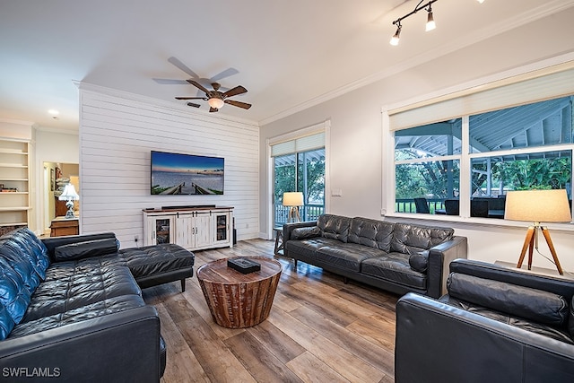 living room featuring crown molding, ceiling fan, rail lighting, and hardwood / wood-style flooring