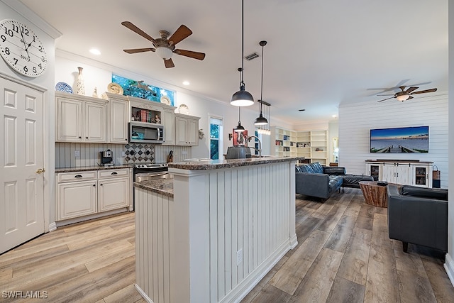 kitchen with light hardwood / wood-style flooring, an island with sink, crown molding, hanging light fixtures, and ceiling fan