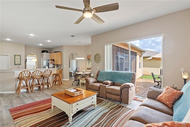 living room featuring ceiling fan and light hardwood / wood-style floors