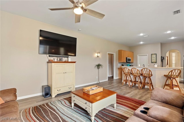 living room featuring ceiling fan and light wood-type flooring