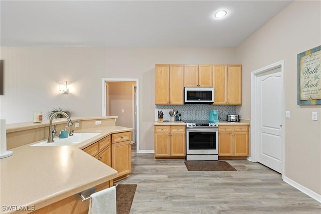 kitchen featuring stainless steel range with electric stovetop, light brown cabinetry, sink, and light hardwood / wood-style floors