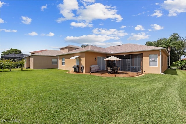 back of property with a yard, a sunroom, and a patio