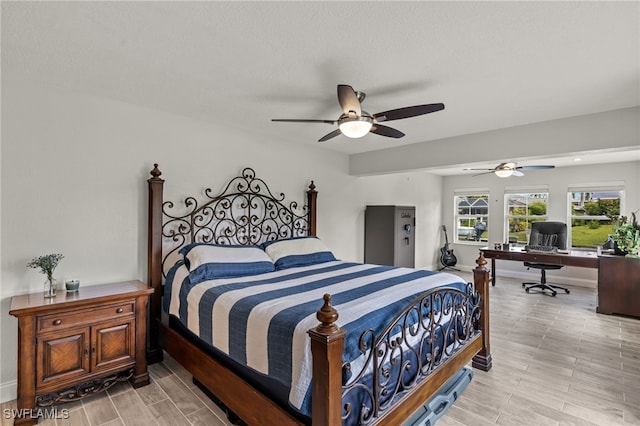 bedroom featuring wood tiled floor, ceiling fan, and baseboards