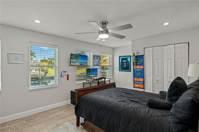 bedroom with light wood finished floors, multiple windows, baseboards, and recessed lighting