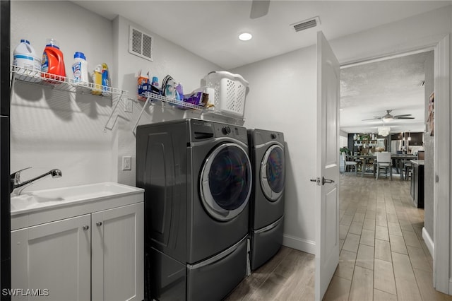 clothes washing area featuring washer and clothes dryer, ceiling fan, and visible vents