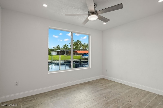 spare room with light wood-type flooring, baseboards, a ceiling fan, and recessed lighting