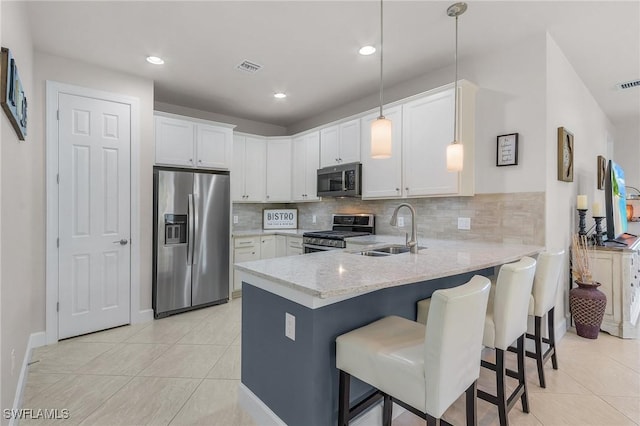 kitchen with pendant lighting, white cabinetry, stainless steel appliances, and sink