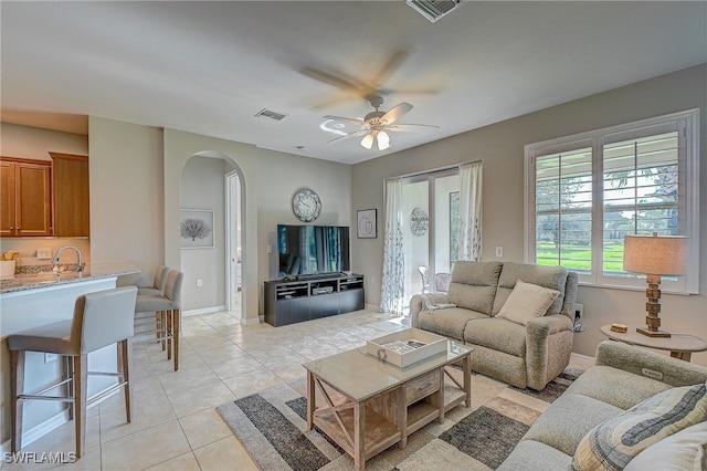 tiled living room with ceiling fan