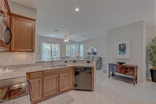 kitchen featuring light stone countertops, black appliances, kitchen peninsula, sink, and ceiling fan