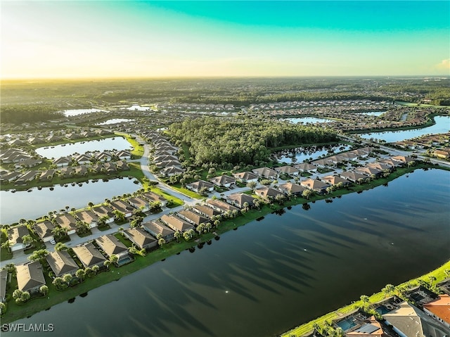 aerial view at dusk featuring a water view