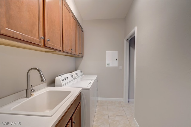 laundry area featuring light tile patterned flooring, cabinets, washer and clothes dryer, and sink