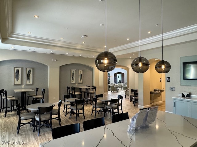 interior space featuring a tray ceiling, light hardwood / wood-style floors, and ornamental molding