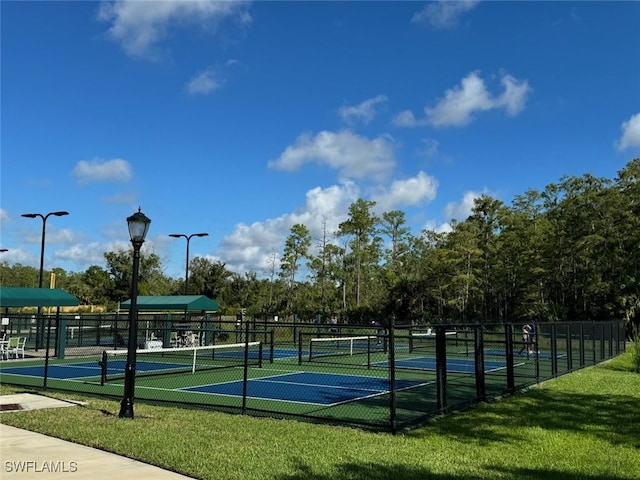 view of tennis court with a yard