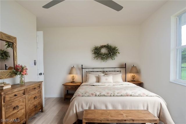 bedroom with multiple windows, hardwood / wood-style flooring, and ceiling fan