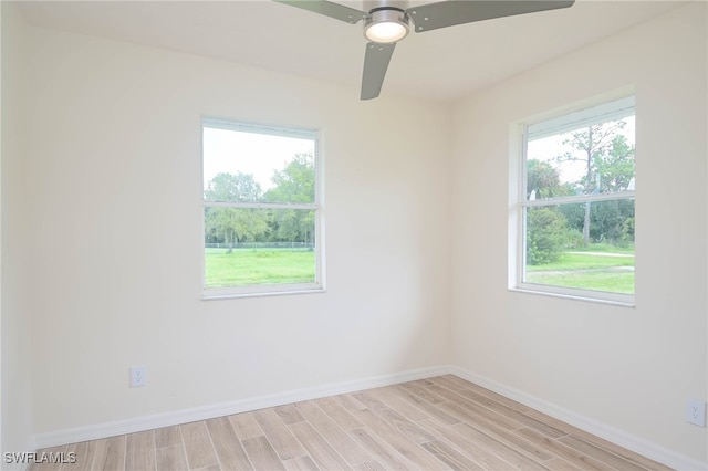 empty room with light wood-type flooring, ceiling fan, and a wealth of natural light