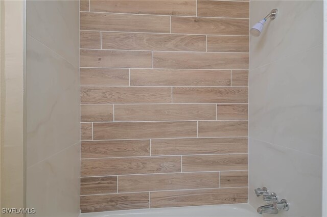 interior details featuring tiled shower / bath combo