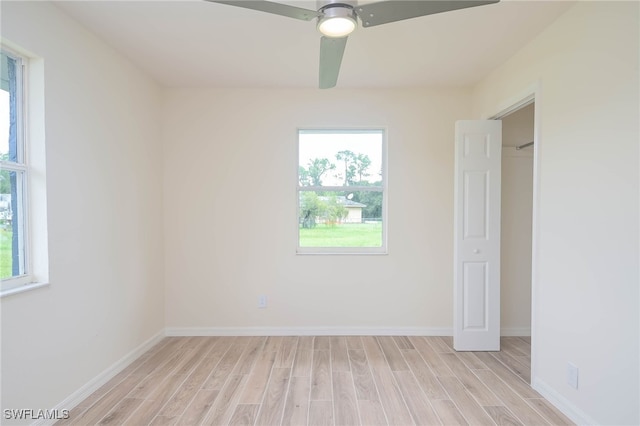 unfurnished room featuring a wealth of natural light, ceiling fan, and light hardwood / wood-style floors