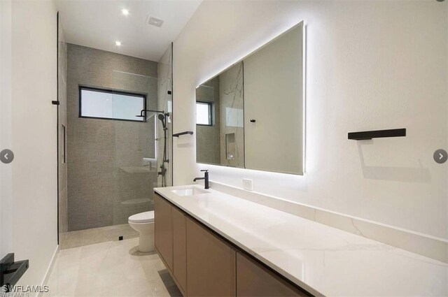 bathroom featuring tile patterned flooring, vanity, toilet, and walk in shower