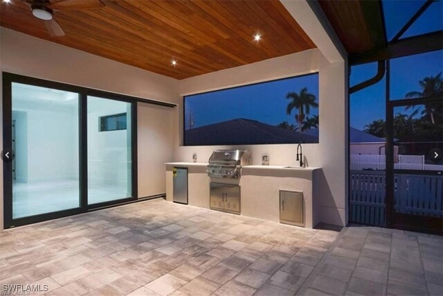 view of patio featuring exterior kitchen, ceiling fan, and grilling area