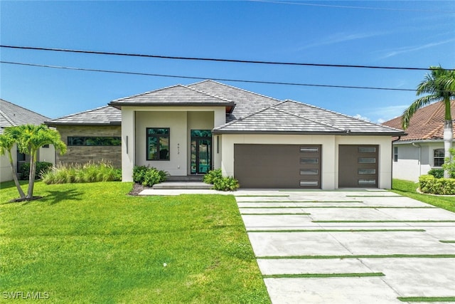 prairie-style house featuring stucco siding, an attached garage, driveway, and a front lawn